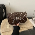 Borsa punk marrone scuro con borchie argentate e tracolla a catena in mano - Marrone