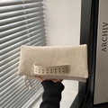 Beige leopard texture clutch bag featuring gold rivet handle shown in hand - White
