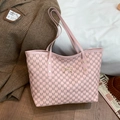 Pink tote bag with letter prints and gold bow detail on a stylish brown suit - Pink