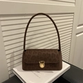 Braune Schultertasche mit Leopardenmuster und goldenem Verschluss vor weißem Buch - Braun