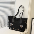 Detail of black cat tote bag with 3D ears and gold rivets under natural window light - Black