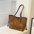 Detail of a brown tote bag featuring a cartoon cat face design and stylish side tassels - Brown