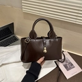 Detail of dark brown patent leather handbag with golden gourd pendant and smooth texture - Dark Brown