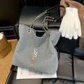 Silver sequin tote bag with gold chain strap and metallic tassel on black leather background - Gray