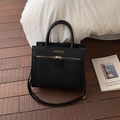 Close-up of textured black leather tote featuring gold zippers and adjustable shoulder strap - No Pendant / Black