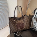 Coffee brown tote bag with M letter print and embossed logo in a luxury setting - Coffee