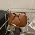 Chic brown pleated shoulder bag with silver chain and drawstring in a cozy setting - Brown
