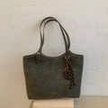 Detalle del bolso tote verde oliva oscuro con costuras blancas y logotipo dorado impreso - Verde con Colgante