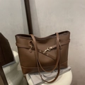 Bolso tote vintage grande de cuero marrón oscuro con hebilla dorada en pedestal minimalista - Marrón