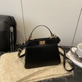 Sac à main en cuir noir avec fermoir doré sur une écharpe en cachemire beige - Noir