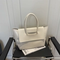 Sac fourre-tout chic blanc à motif crocodile avec rabat sur une chaise moderne - Blanc