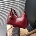 Borsa a mezzaluna bordeaux lucida con ciondolo a sfera dorata e tracolla sottile - Borgogna