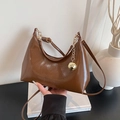 Brown shiny patent leather crescent underarm bag with gold ball charm detail - Brown