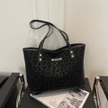 Classic black tote bag with matte leopard print and gold hardware on a modern chair - No Pendant / Black