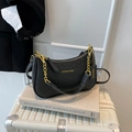 Borsa a tracolla chic nera con trama struzzo e catena dorata su valigia bianca - Nero