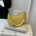 Borsa a mezzaluna gialla con motivo struzzo e catena dorata su una valigia bianca - Oro