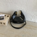 Elegante bolso de media luna en charol negro con hebillas doradas y letras modernas - Negro