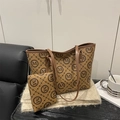Classic brown tote bag set with vintage M pattern and matching pouch on a cozy chair - Brown