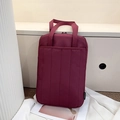 Vertical burgundy quilted laptop tote bag with reinforced handles and brand tag - Red