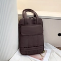 Dark brown quilted tote bag with top handles and front pocket for laptop storage - Brown