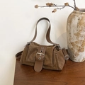 Detail of brown suede crossbody bag with vintage metal buckle on a wooden table - Brown