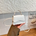 Chic white mini leather crossbody bag with wave flap and top handle in a minimalist style - White