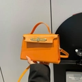 Sac à main orange vif en similicuir avec fermoir rotatif doré et bandoulière fine - Orange