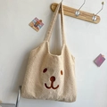 Cute beige fleece tote bag with bear embroidery hanging on a wooden hook - Off White