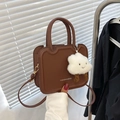 Detail of a brown leather shoulder bag with wavy edges and a cloud pendant - Dark Brown