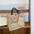 Borsa tote in lino con ricamo mama e frange colorate su uno scaffale di legno - Stile nappa