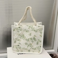 Détail du sac cabas en dentelle blanche avec motifs verts et anses en corde tressée - Vert
