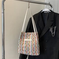 Dettaglio della borsa tote intrecciata colorata con manici bianchi ed etichetta moda - Rosso