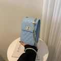 Detail of light blue quilted phone bag with gold chain strap and adjustable ball buckle - Blue