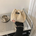 Beige hand-woven straw bucket bag with drawstring closure and silver chain strap - Off White