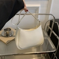 Detailed close-up of a white crescent shoulder bag with matte finish and stitching details - White