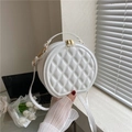 Primer plano de un bolso redondo acolchado blanco con elegantes cremalleras doradas - Blanco