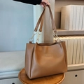 Close-up of caramel PU leather tote bag with gold chain strap detail and FASHION logo - Caramel color
