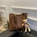 Brown leather tote bag with gold chain strap and teddy bear charm on black sofa - Dark Brown Without Pendant
