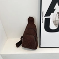 Detalle de un bolso bandolera de pana marrón con cremalleras dobles en escalón blanco - café