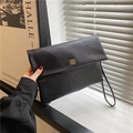 Elegante pochette a busta nera martellata con fibbia a fiore dorato e cinturino - Nero