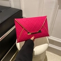 Detail of rose pink quilted envelope clutch featuring elegant gold metal trim and clasp - Rose Red