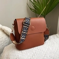 Braune Beuteltasche aus Kunstleder mit einem breiten geometrisch gemusterten Schultergurt - Braun