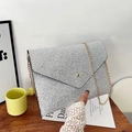 Pochette a busta glitterata argento con catena dorata in un'ambientazione lifestyle - Argento