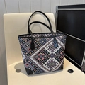 Detalle de bolso tote étnico con estampados geométricos de colores y ribete de cuero - Negro