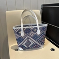 Detalle de bolso tote étnico con patrones geométricos de colores y asas de cuero - Blanco