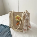 Detailansicht der gewebten Strohtasche mit gelber Blume und buntem Seidenschal-Accessoire - Weiß