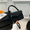 Elegant black woven texture crossbody bag with unique knot handle and golden hardware details - Black