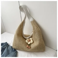 Detail of hand-woven straw shoulder bag with leather strap and decorative 3D flower charm - White