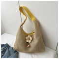 Macro detail of hand-woven mesh tote bag with yellow leather strap and fabric flower - Yellow