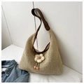 Detail of summer straw tote bag featuring a beige woven texture and floral charm - Coffee